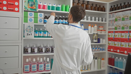 Back view of a man in a lab coat reaching for a product on a pharmacy shelf, depicting healthcare retail.