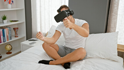 A young man experiencing virtual reality gaming while sitting on a bed in a modern bedroom