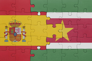 puzzle with the colourful national flag of suriname and flag of spain.