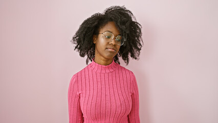 African american woman wearing glasses poses against a pink background, evoking elegance and...