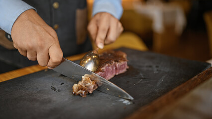 Young man carving meat at the restaurant