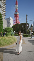 Vibrant hispanic woman, beaming with joy, poses in glasses at tokyo's famous urban spot, spreading...