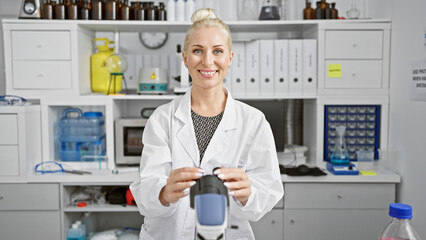 Confident young blonde woman scientist smiling as she discovers new insights using her microscope in the buzzing lab