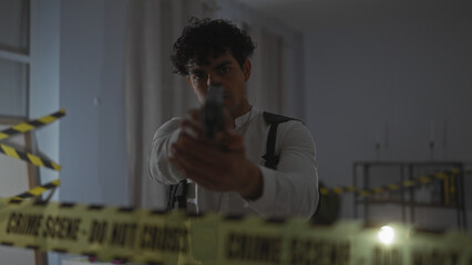 Hispanic man aiming gun at indoor crime scene with caution tape, suspenseful atmosphere.