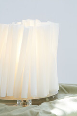 White sculptural papercraft lamp. Mid-century modern decor. Close-up photograph.