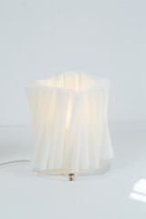 White sculptural papercraft lamp. Mid-century modern decor. Close-up photograph.