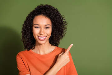 Photo portrait of lovely young lady point empty space dressed stylish orange garment isolated on...