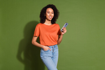 Photo portrait of lovely young lady hold device dressed stylish orange garment isolated on khaki color background