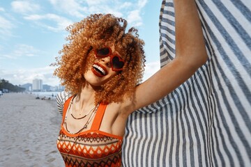Summer Bliss: A Happy, Smiling African Female Model Enjoying a Carefree Day at the Beach in a Sunny...