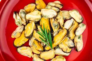 Mussels on a large red plate close-up top view
