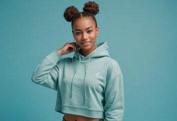 A young woman in a mint hoodie strikes a playful pose, embodying the comfortable yet fashionable athleisure trend.