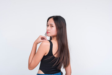 A young asian woman in a black bodysuit, looking behind her shoulder. Isolated on a white background.