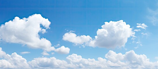A picturesque scene showing a clear blue sky with fluffy white clouds, providing a serene copy space image.