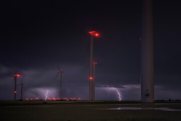 Electrical storm at night over a wind turbine field. Renewable energy concept © patxi