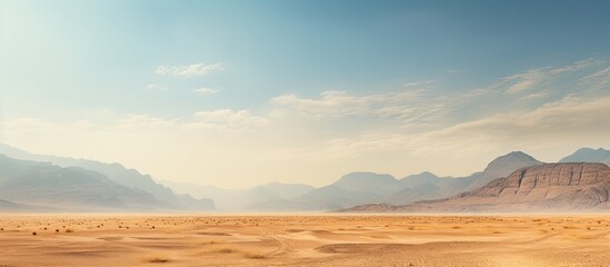 A scenic bare mountain range and sandy valley desert in the Middle East or Africa make a captivating landscape for photography with ample copy space image in a horizontal frame.