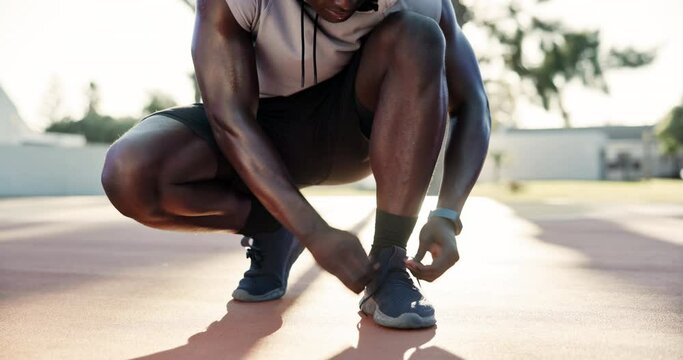 Sports, tie shoes and hands on basketball court to start training, cardio workout or game. Athlete, legs and black man fix trainers for preparation, exercise or getting ready in outdoor park of Miami