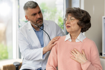 Doctor examining female elderly patient, suffering from heart pain, male doc explaining the...