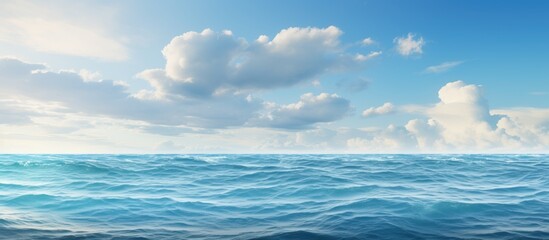 Fototapeta premium Seascape background featuring a beautiful blue sea under a cloud-filled sky with copy space image.