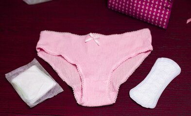 Sanitary pads and menstrual pink underwear. Period cycle hygienic accessories. Puberty female...