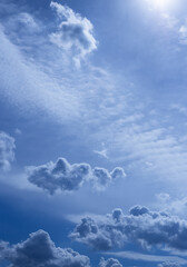 Vertical cloudy sky sunny day  photo. Blurred blue sky with white single cloud. Selective focus. Defocused skyscape with copy space.