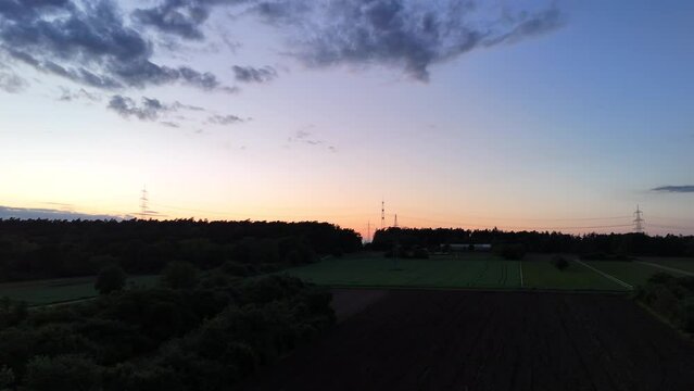 Landschaft mit Strommasten, abends