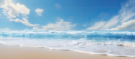 Beach scene on a sunny day with waves, sand, and a clear blue sky providing a peaceful backdrop for a copy space image.