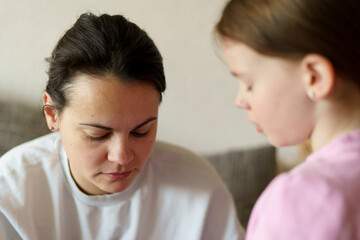 Sad mother and her daughter in the living room
