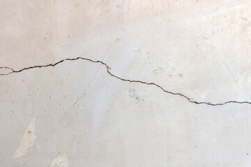 Cracked concrete wall covered with a gray cement surface as a background
