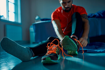 Man tying running shoes before workout