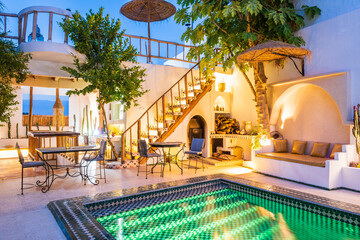 Illuminated with lights courtyard with swimming pool of traditional riad guesthouse in the evening...