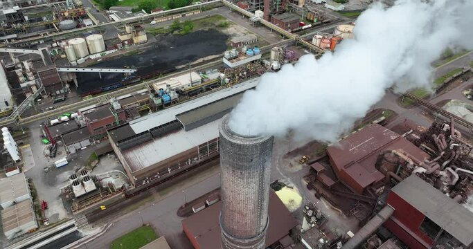 Drone turning around Smokestack with smoke coming out at Krefeld Uerdingen chemical park in Germany