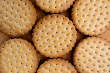 Sandwich cookies, chocolate cream filled biscuit stuck on brown yellow background. Modern cookies concept.
