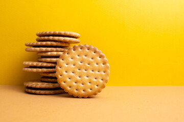Sandwich cookies, chocolate cream filled biscuit stuck on brown yellow background. Modern cookies...