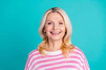 Photo of adorable pensioner nice woman with blond hairstyle wear striped sweatshirt toothy smiling isolated on blue color background