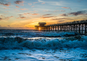 Cocoa Beach Pier on the beach with waves at sunrise