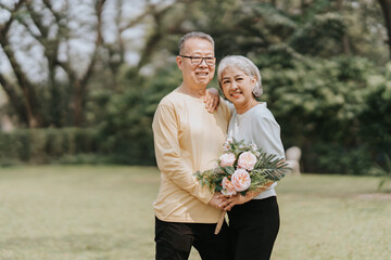 Asian senior couple having a good time They laughed and smiled outdoors in the park. cute senior couple