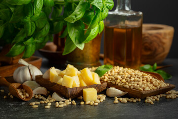 Ingredients for making Pesto sauce on a black stone table.