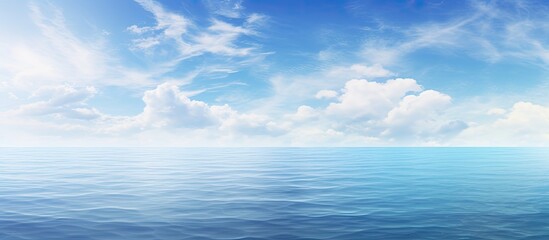 Seascape featuring a tranquil sea under a vast blue sky with trees on the horizon, providing a serene backdrop for a copy space image.