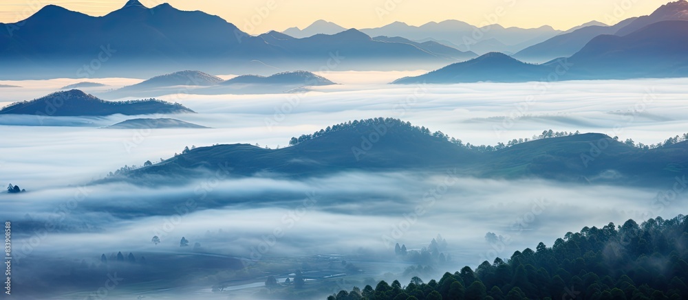 Poster mountain sunrise with mist creating an ethereal atmosphere, perfect for a copy space image.
