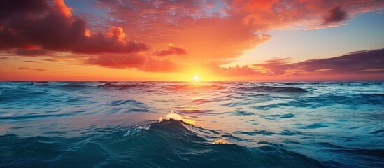 Obraz premium Beautiful turquoise waves in the ocean off the coast of Cozumel with a stunning sunset in the background in this copy space image.