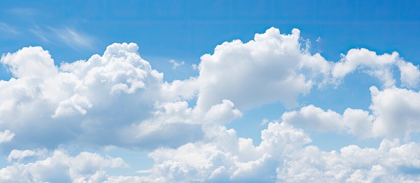 A serene blue sky featuring fluffy white clouds, perfect as a copy space image.