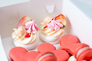 Set of pastries for St Valentine's day of for any romantic day packed in a cardboard box. Heart shaped macaroons and mini cakes