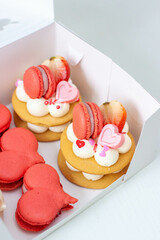 Set of pastries for St Valentine's day of for any romantic day packed in a cardboard box. Heart shaped macaroons and mini cakes