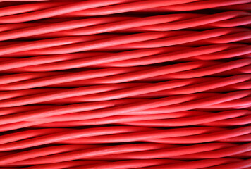 High voltage power line with red insulated cable against a background