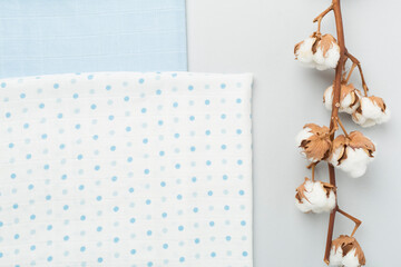 Cotton fabric with branch on color background, top view