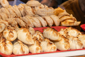 Close up of a display with large number of freshly prepared empanadas