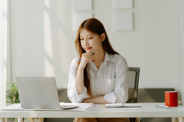 Adorable businesswoman holding coffee cup while working in the office room.