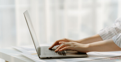 Learn online, Woman watching live video or video call of teacher teaching on laptop in her home, Take notes of important conversations and messages during the