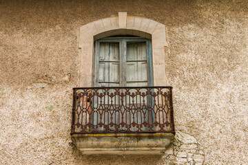 Ventana esgastada por el paso del tiempo, antigua y vieja con barandal de hierro forjado oxidado en...