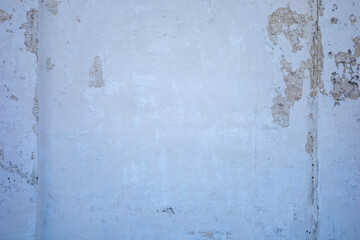 photo of white concrete wall with cracks and peeling paint texture